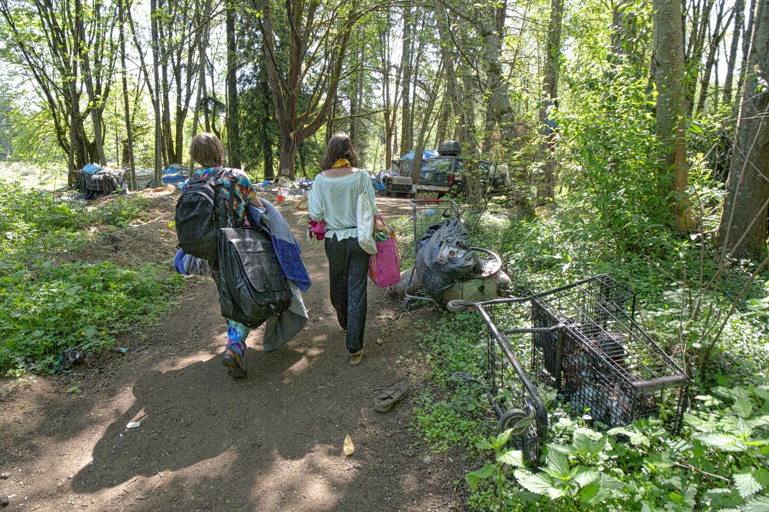 Casey and Bridget, searching in Olympia's Jungle homeless camp, for a spot on which to make camp. May 12, 2023.